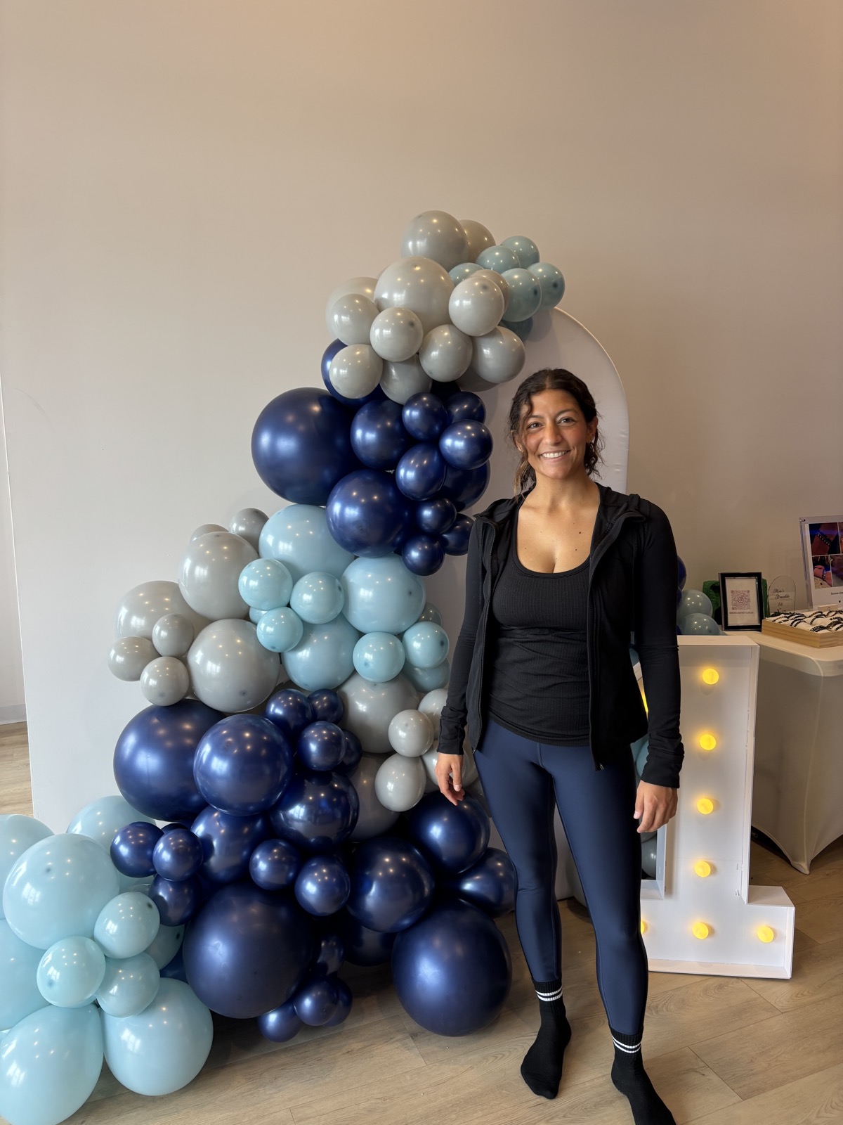 Lisa beside a navy and dove blue first-birthday garland
